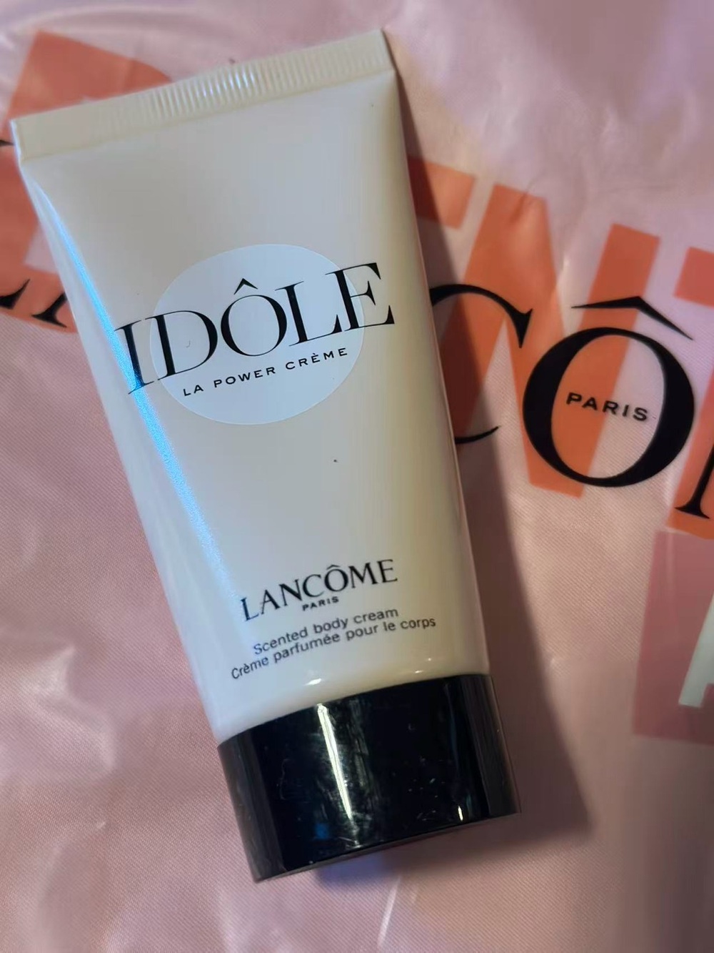 Lancome Idôle Scented Body Cream - White Tube with Black Cap on Pink Background